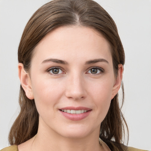 Joyful white young-adult female with medium  brown hair and grey eyes