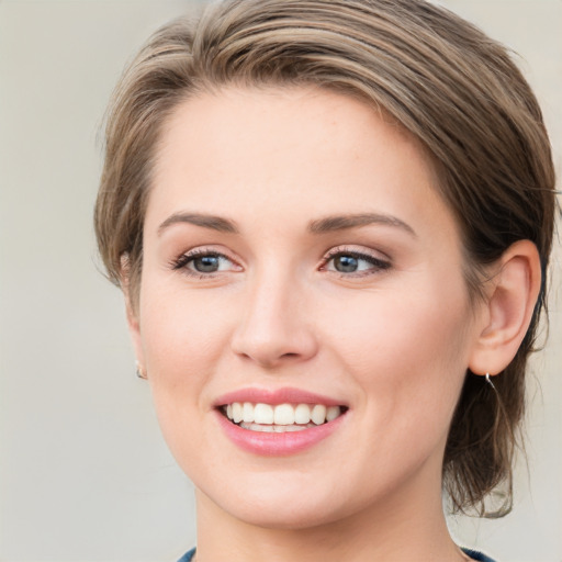 Joyful white young-adult female with medium  brown hair and green eyes