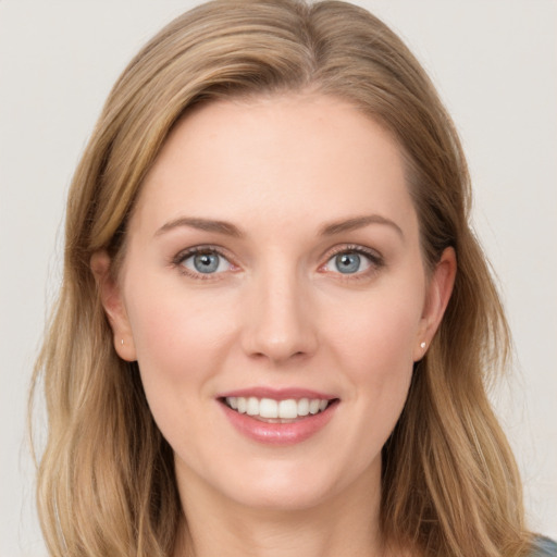 Joyful white young-adult female with long  brown hair and blue eyes