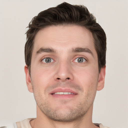 Joyful white young-adult male with short  brown hair and grey eyes