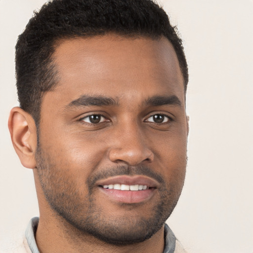 Joyful black young-adult male with short  brown hair and brown eyes