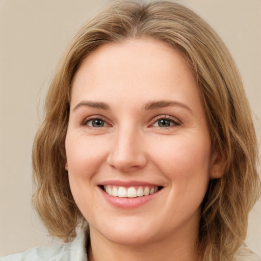 Joyful white young-adult female with medium  brown hair and green eyes