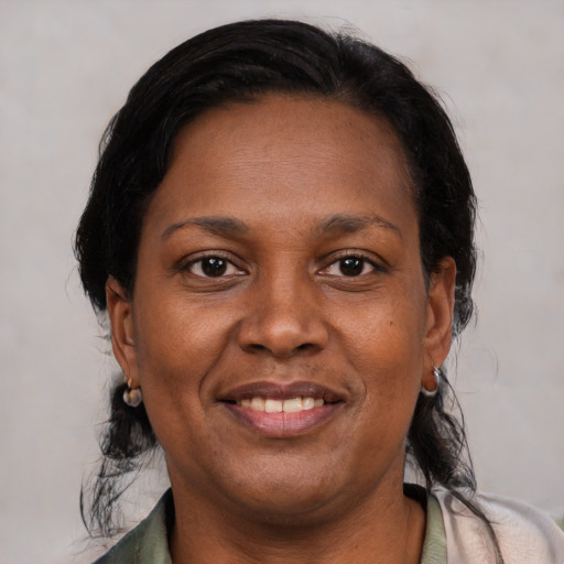 Joyful latino adult female with medium  black hair and brown eyes