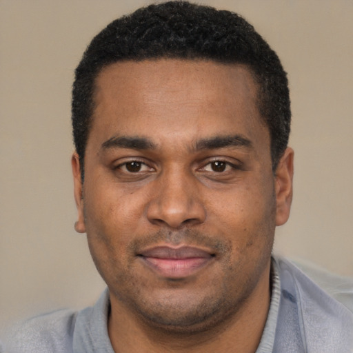 Joyful black young-adult male with short  black hair and brown eyes