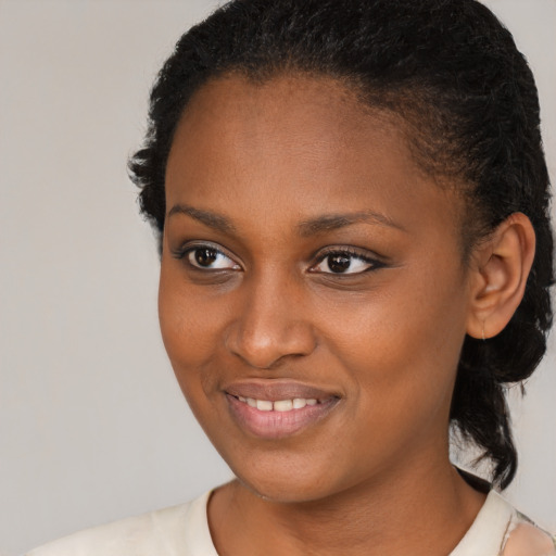 Joyful black young-adult female with medium  brown hair and brown eyes