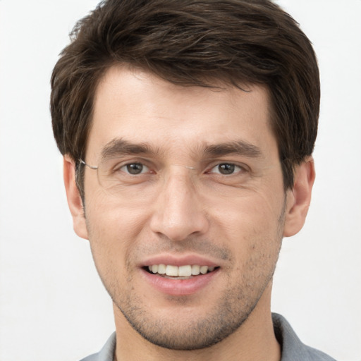 Joyful white young-adult male with short  brown hair and grey eyes