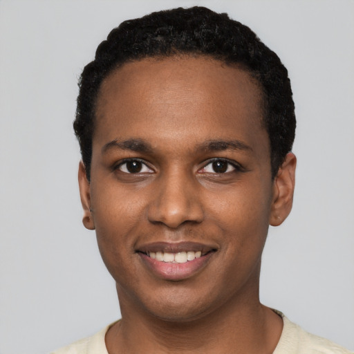 Joyful black young-adult male with short  black hair and brown eyes