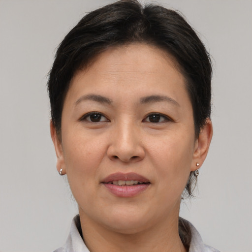Joyful asian adult female with short  brown hair and brown eyes