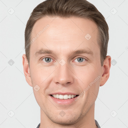 Joyful white young-adult male with short  brown hair and grey eyes