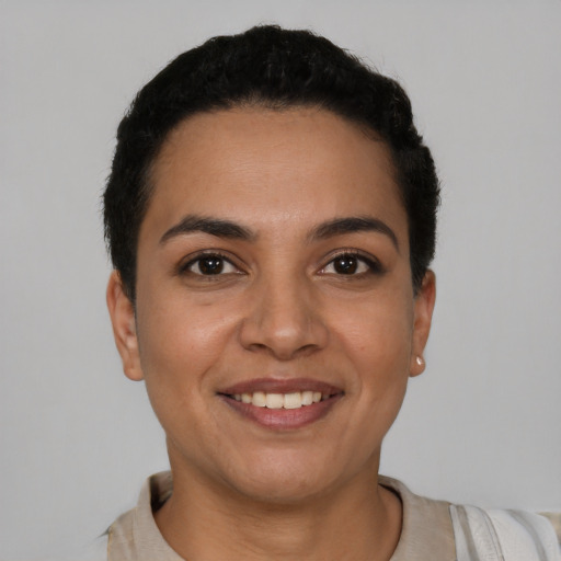 Joyful latino young-adult female with short  black hair and brown eyes