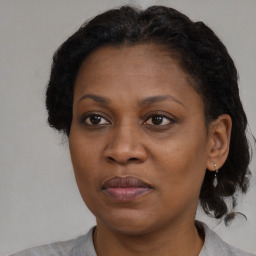 Joyful black adult female with medium  brown hair and brown eyes