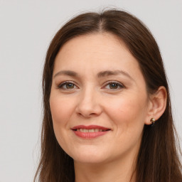 Joyful white adult female with long  brown hair and brown eyes