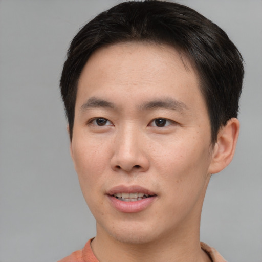 Joyful asian young-adult male with short  brown hair and brown eyes