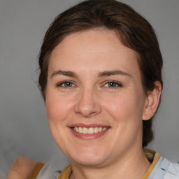 Joyful white adult female with medium  brown hair and blue eyes