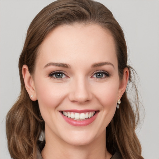 Joyful white young-adult female with medium  brown hair and grey eyes