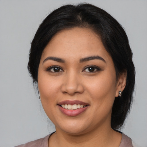 Joyful latino young-adult female with medium  black hair and brown eyes