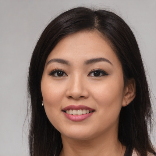 Joyful asian young-adult female with long  brown hair and brown eyes