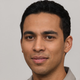 Joyful latino young-adult male with short  black hair and brown eyes