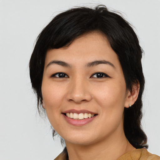 Joyful asian young-adult female with medium  black hair and brown eyes