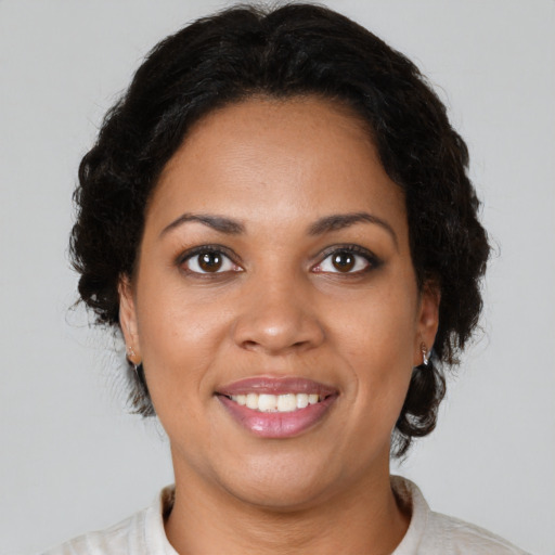 Joyful black young-adult female with short  brown hair and brown eyes
