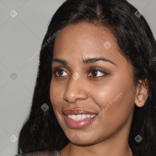 Joyful black young-adult female with long  black hair and brown eyes