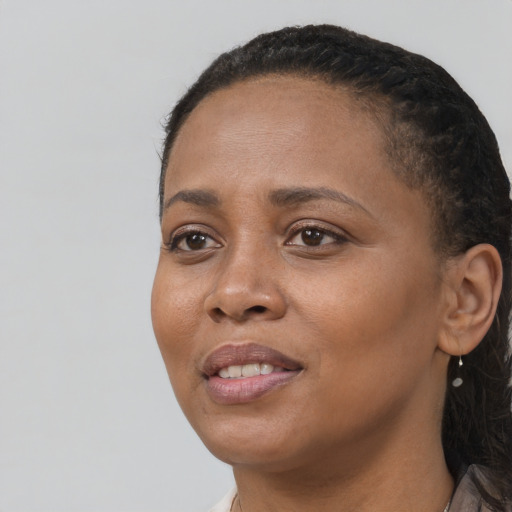 Joyful black young-adult female with long  black hair and brown eyes