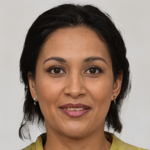 Joyful latino adult female with medium  brown hair and brown eyes