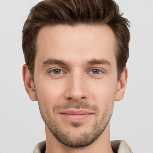 Joyful white young-adult male with short  brown hair and grey eyes