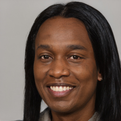 Joyful black adult female with long  black hair and brown eyes