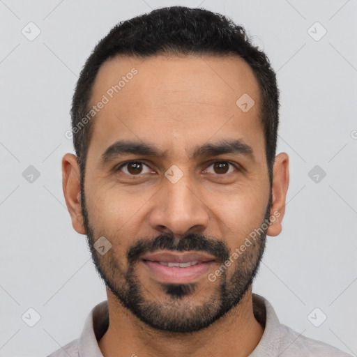 Joyful latino young-adult male with short  black hair and brown eyes