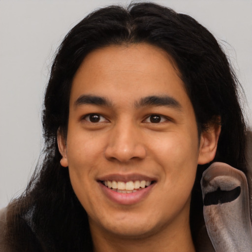 Joyful latino young-adult male with long  black hair and brown eyes