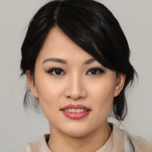 Joyful asian young-adult female with medium  black hair and brown eyes