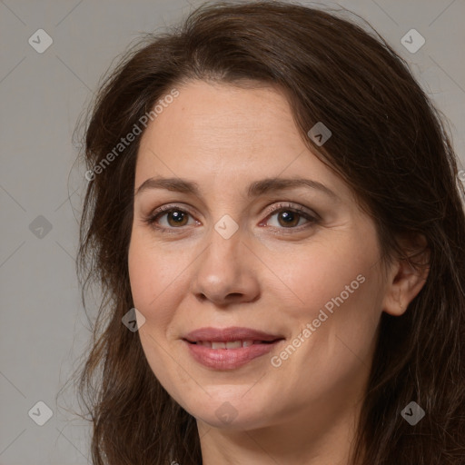 Joyful white adult female with long  brown hair and brown eyes