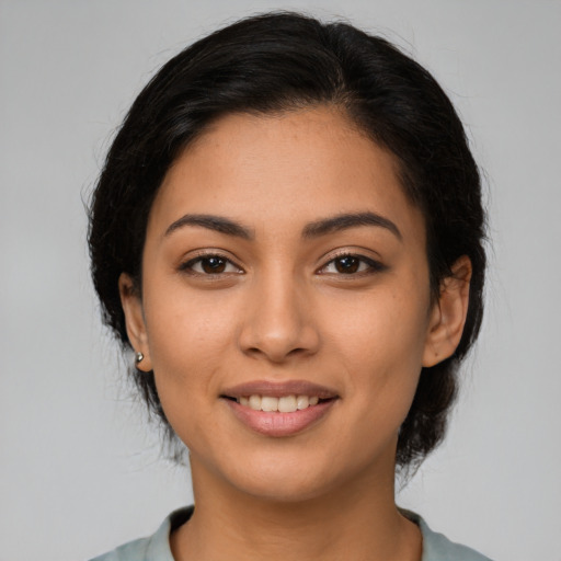 Joyful latino young-adult female with medium  brown hair and brown eyes