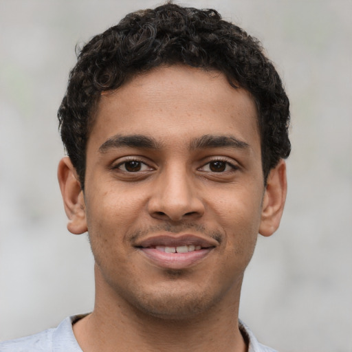 Joyful latino young-adult male with short  brown hair and brown eyes
