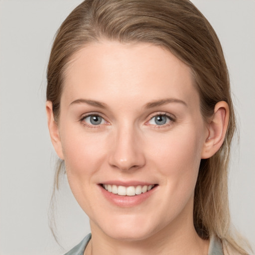 Joyful white young-adult female with medium  brown hair and blue eyes