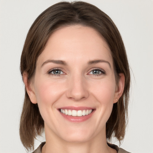 Joyful white young-adult female with medium  brown hair and grey eyes