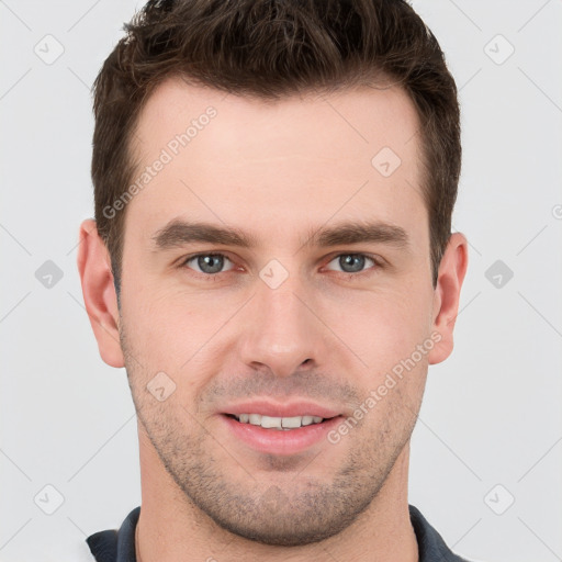 Joyful white young-adult male with short  brown hair and grey eyes