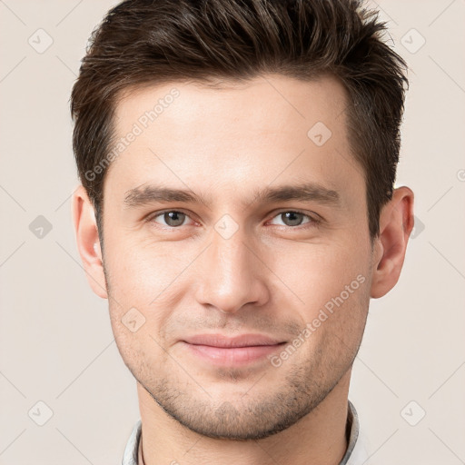 Joyful white young-adult male with short  brown hair and grey eyes