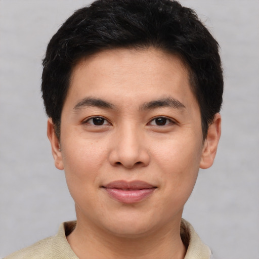 Joyful asian young-adult male with short  brown hair and brown eyes