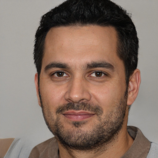 Joyful white young-adult male with short  black hair and brown eyes