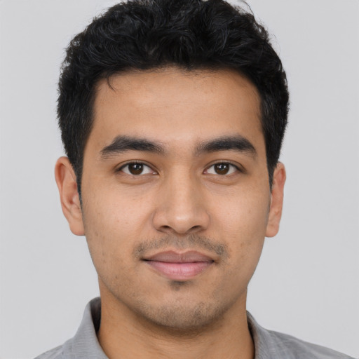 Joyful latino young-adult male with short  black hair and brown eyes