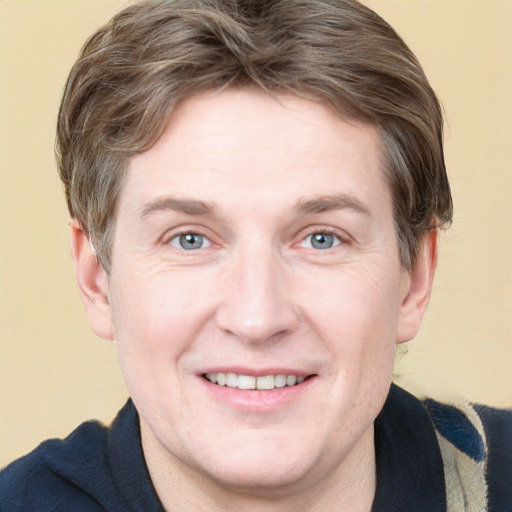 Joyful white adult male with short  brown hair and blue eyes