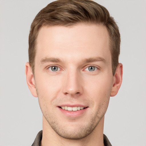 Joyful white young-adult male with short  brown hair and grey eyes