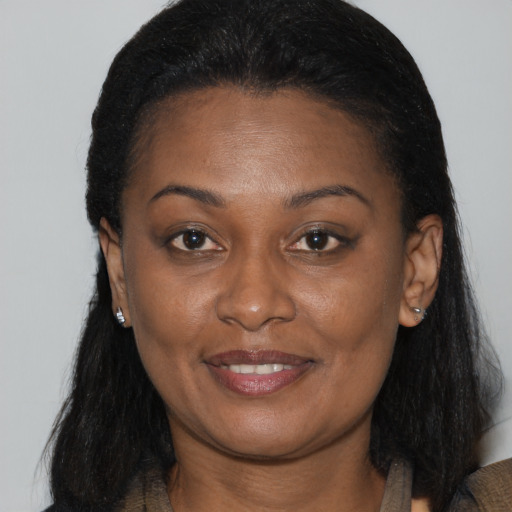 Joyful black young-adult female with long  brown hair and brown eyes