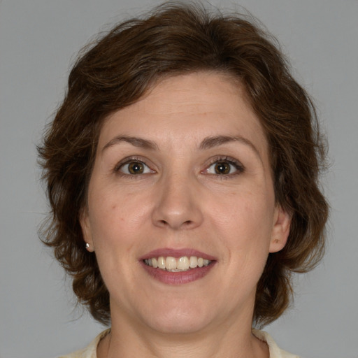 Joyful white adult female with medium  brown hair and green eyes