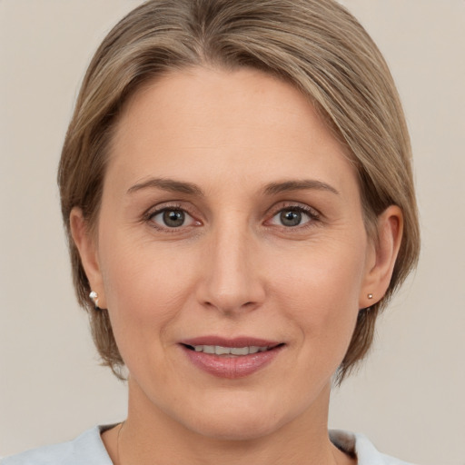 Joyful white adult female with medium  brown hair and grey eyes