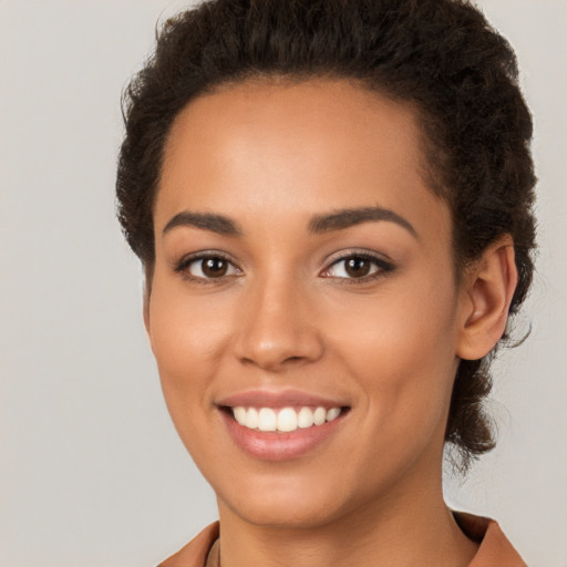 Joyful latino young-adult female with short  brown hair and brown eyes