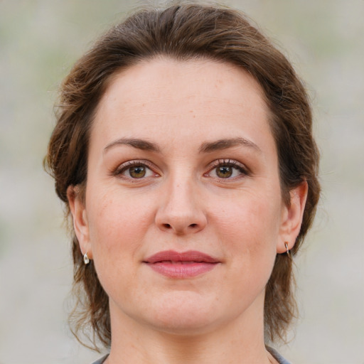 Joyful white young-adult female with medium  brown hair and green eyes