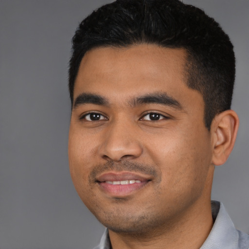 Joyful latino young-adult male with short  black hair and brown eyes